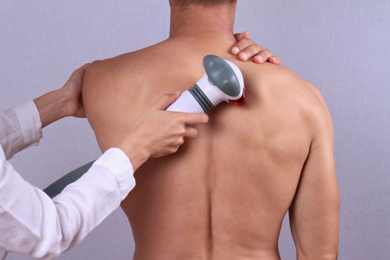 man receiving red light therapy on back