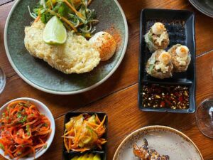 Various vegan dishes of Asian cuisine, spread out on a wooden table